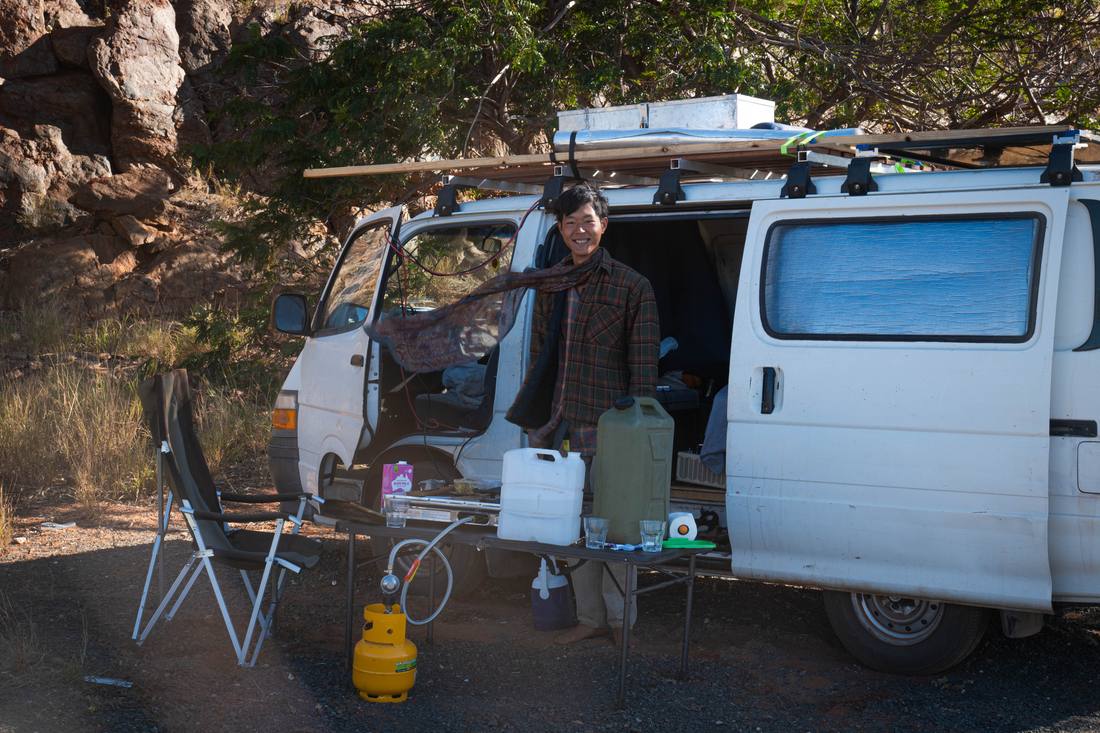 Yechan Jeon smiling beside a campervan at a bush campsite
