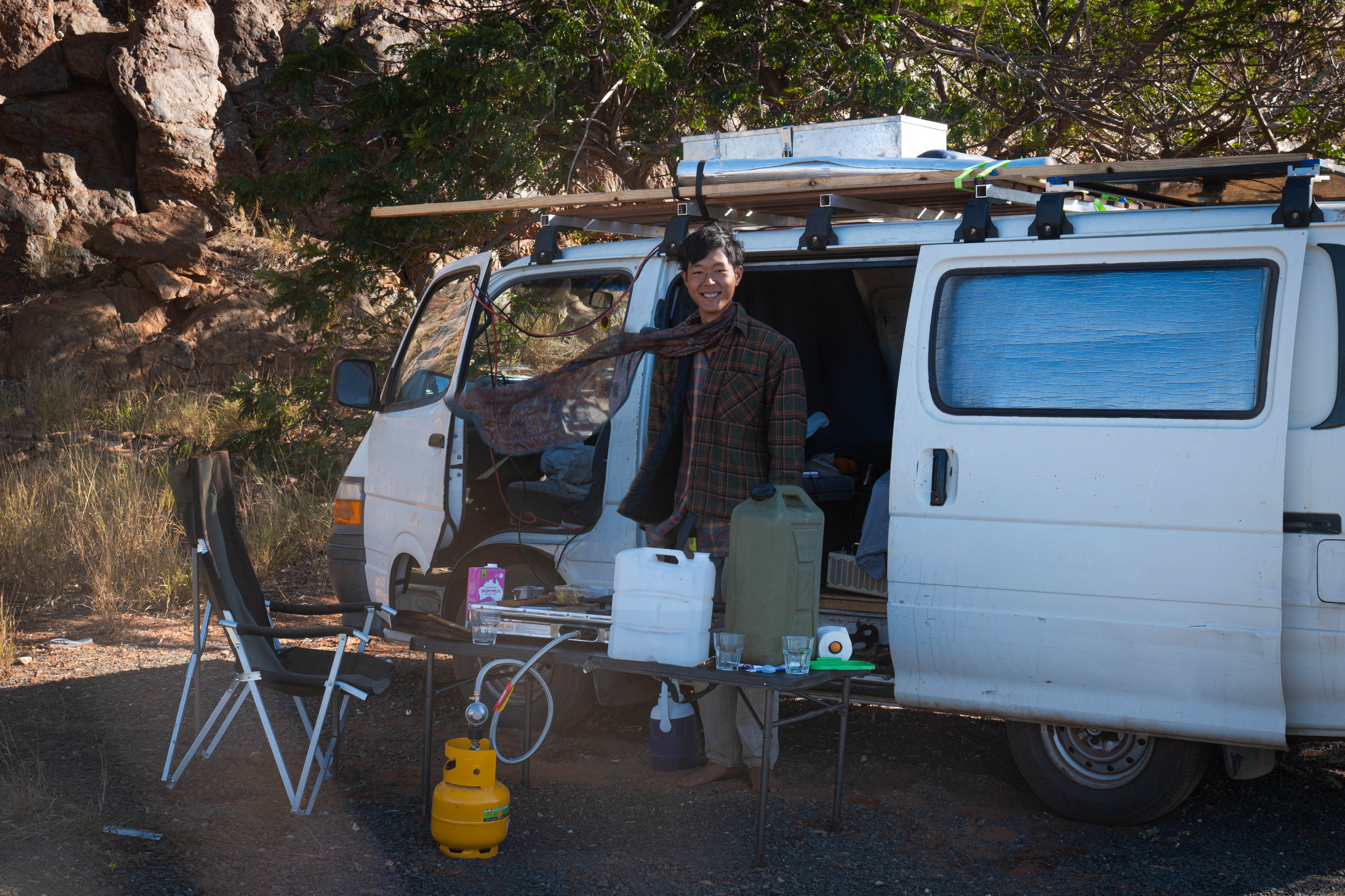 Yechan Jeon smiling beside a campervan at a bush campsite